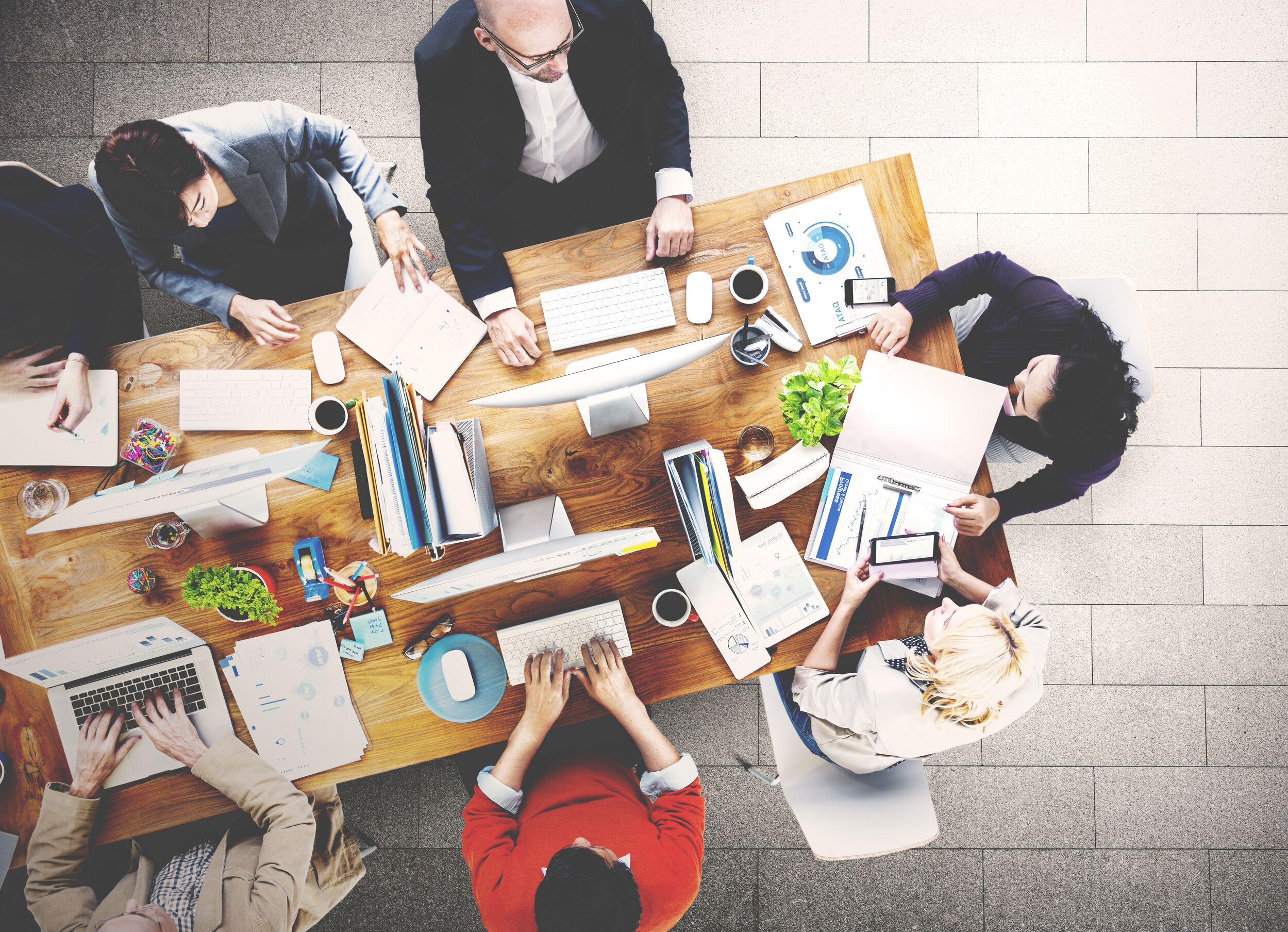 Overhead view of coworkers working at a table.
